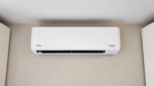 Fujitsu Halcyon wall-mounted mini-split air conditioner installed high on a beige interior wall.