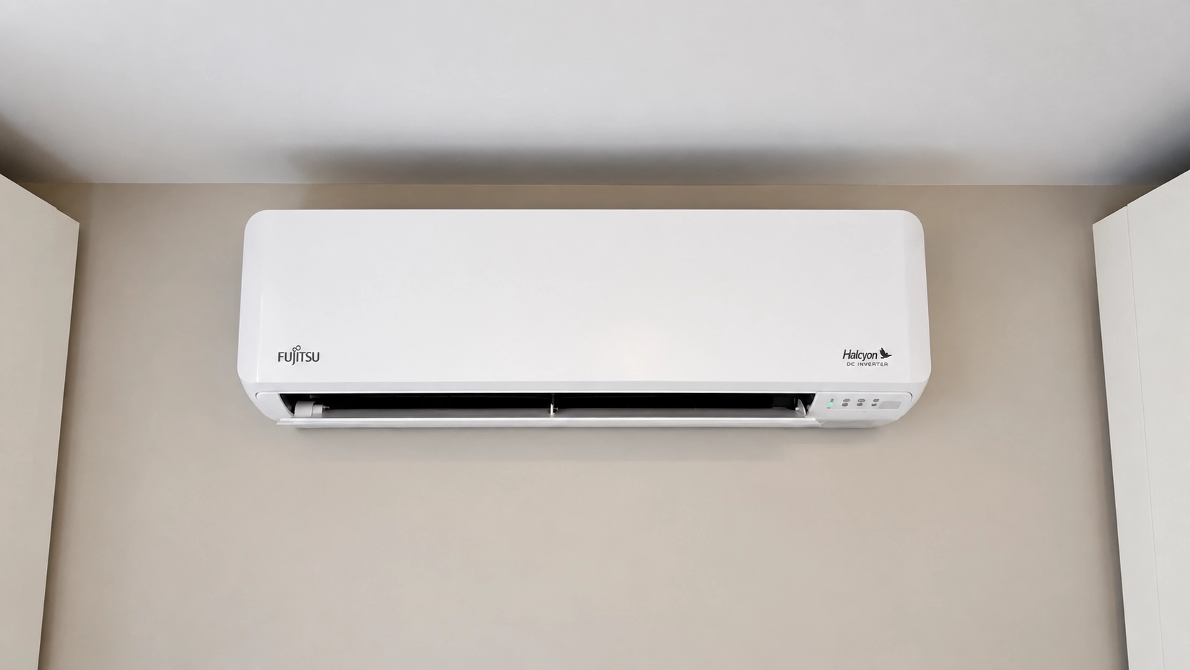 Fujitsu Halcyon wall-mounted mini-split air conditioner installed high on a beige interior wall.